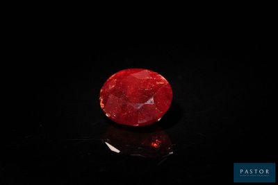 un gros plan d'une pierre rouge sur une surface noire