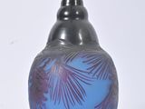 a blue vase that has a palm leaf design on it