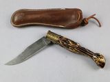 a knife that is sitting next to a leather sheath