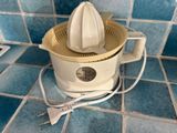 a white juicer sitting on a blue tiled counter