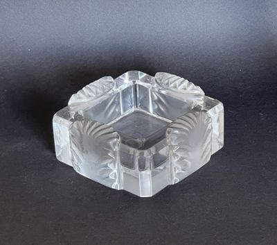 an image of a clear glass ashtray on a black surface