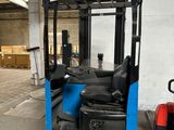 un chariot élévateur dans un entrepôt, peint en bleu et noir