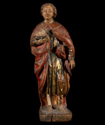 une vieille statue en bois représentant un homme coiffé d'un chapeau et vêtu d'une robe