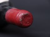a close up of a bottle of wine with a red cap