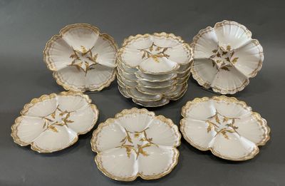 six assiettes blanches et dorées ornées de fleurs, posées sur une table