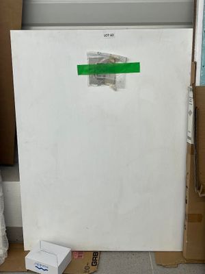 un réfrigérateur blanc posé dans une pièce, entouré de cartons