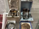 une table en verre sur laquelle sont disposés des objets en argent, dans une vitrine