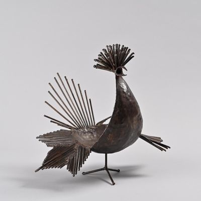 une image représentant une statue d'oiseau en métal sur fond blanc