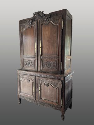 une grande armoire en bois avec un plateau sculpté