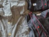 three men ' s pajamas and shirts laid out on a bed
