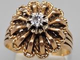 a close up of a gold ring with a diamond in the center