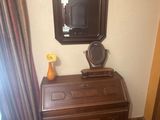 une commode sur laquelle sont posés un miroir et un vase