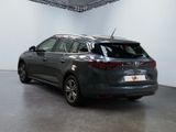 the back of a grey car is parked in a white room