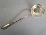 a silver spoon with a spoon handle on a table