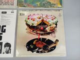 three records on a table with a cake on it