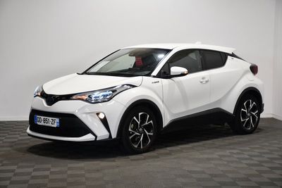 une Toyota C-HR blanche garée dans une pièce au sol à carreaux