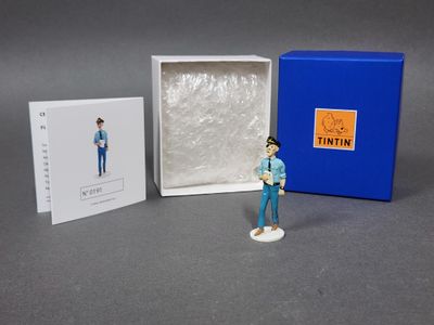 une petite figurine représentant un homme en chemise bleue et en jean