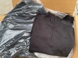 un pull noir et un pull marron dans une boîte