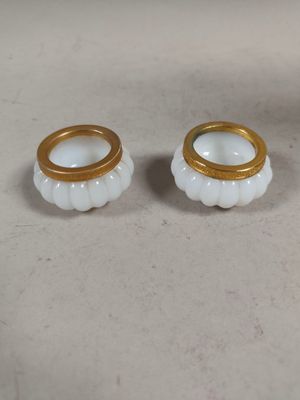 pair of white and gold candlestick holders with gold rims