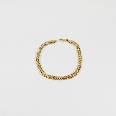 un bracelet en chaîne en or sur fond blanc