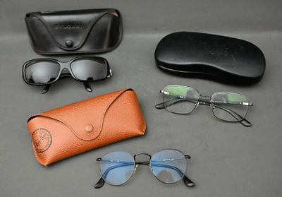 des lunettes de soleil, un étui à lunettes de soleil et des lunettes posées sur une table à côté d'une paire de lunettes