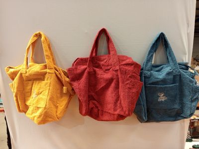 trois sacs sont accrochés au mur d'un magasin