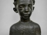 a bronze busturine of a young boy with a flowered head