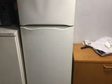 two refrigerators that are next to each other in a room