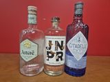 trois bouteilles d'alcool posées sur une table en bois