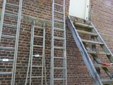 ladders leaning up against a brick building next to a window