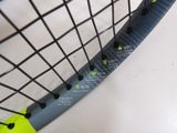 a close up of a tennis racket with a yellow ball