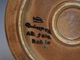 a close up of a brown plate with writing on it