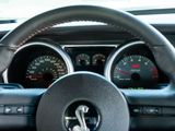 steering wheel of a car with a speedometer, gauges, and a dash board