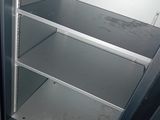 a metal shelf that is open in the corner of a room