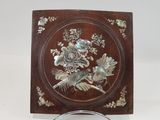 a wooden plaque with a bird and flowers on it