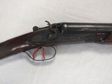 a close up of a gun on a white surface with a red handle