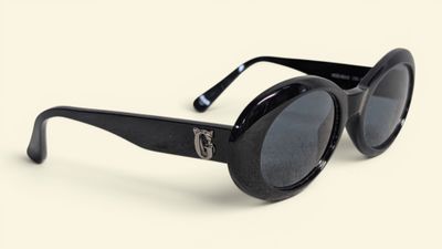 black cat eye sunglasses on a white surface with a white background