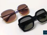 deux paires de lunettes de soleil posées l'une sur l'autre sur une surface blanche