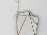 several pieces of white paper tied to a string on a white surface