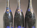 trois bouteilles de champagne posées côte à côte sur une table