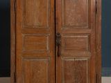 an old wooden cabinet with two doors and a door handle