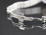a close up of a silver bracelet on a black surface