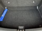 the trunk of a red car with a blue object in the trunk