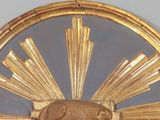 a gold frame with a picture of an elephant and a sunburst