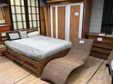 un lit composé d'un cadre en bois et d'une chaise