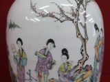 a vase with a painting on it on a red surface