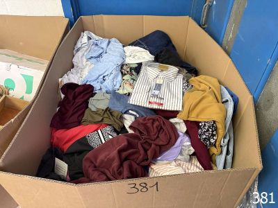 a cardboard box full of clothes on the floor