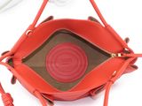 someone is holding a red purse with a red handle and a white glove