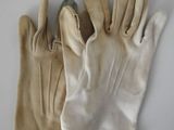 two pairs of leather work gloves on a white surface