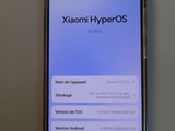 a close up of a cell phone with the text xiaomi hyperos on the screen